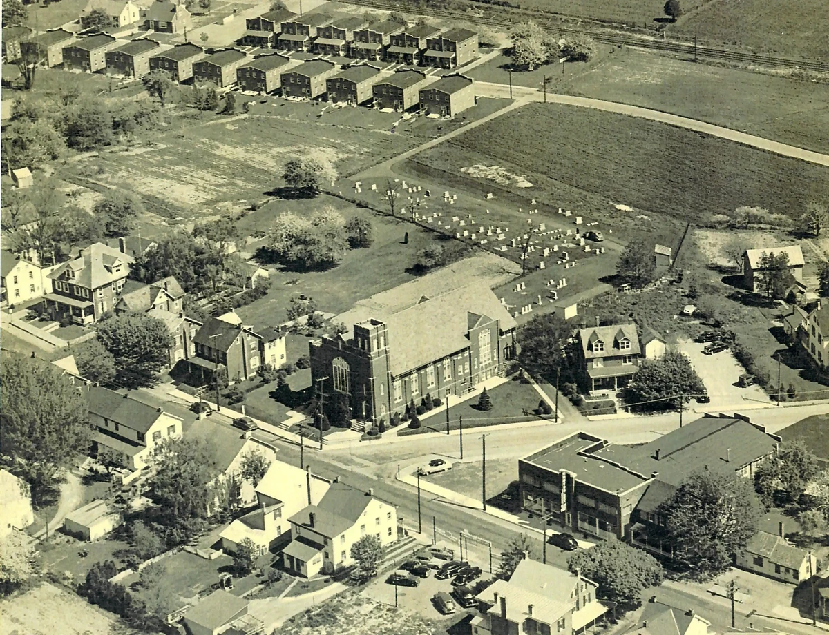 A monochrome aerial view of New Holland in the 1930s with the corner of West Main and Diller in the foreground, and houses along Locust Avenue in the distance.